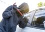 car theft - thief trying to break into the vehicle